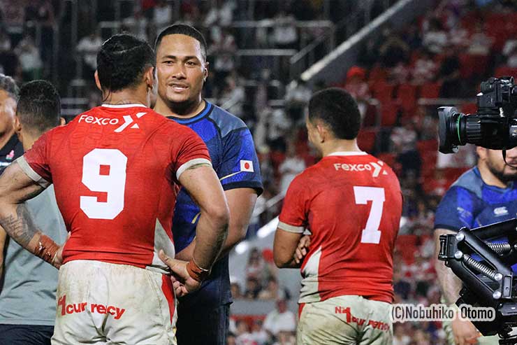 試合後、談笑するタクルア主将(背中)と日本のヴァル。ハイスクール時代の友人だ