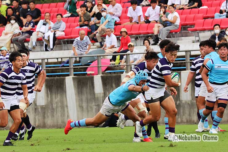 前半19分、明大CTB廣瀬主将が筑波大No8谷山主将のタックルを受けながらオフロードパス
